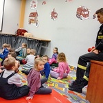 Dzieci rozmawiają ze strażakiem o zachowaniu się podczas pożąru.jpg