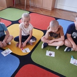 Dzieci siedza na dywanie z obrazkami dotyczącymi zmysłów.jpg