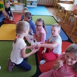 Dziewczynka częstuje dzieci precelkami.jpg