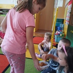 Dziewczynka częstuje dzieci ciastkami.jpg