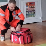 3. Ratownik medyczny prezentuje przenośny zestaw pierwszej pomocy.jpg