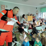 12. Ratownik medyczny rozdaje kolorowanki dzieciom.jpg
