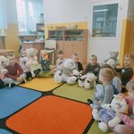 Dzieci siedzą na dywanie z pluszowymi misiami.jpg