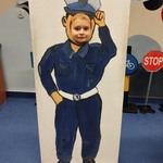 Chłopiec pozuje do zdjęcia za planszą z otworem na głowę i sylwetką policjanta1.jpg