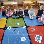 Dzieci siedzą przed siecią z nici_ która symbolizuje Internet.jpg