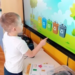 Chłopiec segreguje śmieci na tablicy multimedialnej.jpg