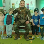 Dzieci przymierzają wojksowe nakrycia głowy.jpg