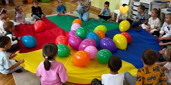dzieci bawią się chustą i balonami