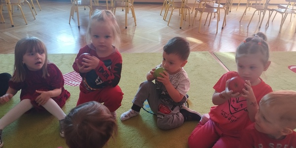 Dzieci wąchają i oglądają jabłka