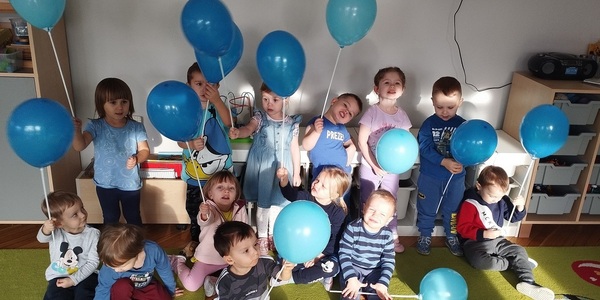 Dzieci stoją z balonami.