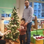 7 Dziecko wspólnie z rodzicami ubiera choinkę.