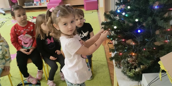 Dziewczynka zawiesza bombkę na choince 1