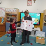 Chłopiec umieszcza odpowiednie emotikonki na tablicy magnetycznej.