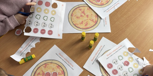 dzieci komponują własną pizzę.