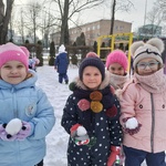 Dziewczynki trzymają śniegowe kulki.