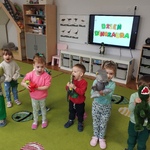 Dzieci stoją z dinozaurami- zabawkami.