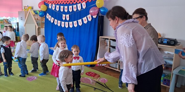 Pani wicedyrektor kładzie ołówek na ramieniu chłopca.
