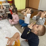 dzieci układają snieżynki na nosie.