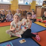 Dziewczynki trzymają karty pracy.