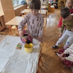 Marcelinka sypie ziemię do doniczki.