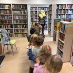 Dzieci stoją w kolejce czekając na zwiedzanie biblioteki.