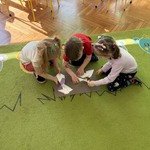 Dzieci układają puzzle na dywanie.
