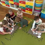 Dzieci w małych grupach układają puzzle.