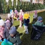 Dzieci sprzątają otoczenie przedszkola.