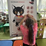 dziewczynka przyczepia odznakę.