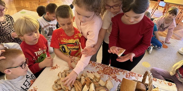 dzieci częstują się pieczywem.