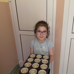 dziewczynka niesie muffinki do kuchni.
