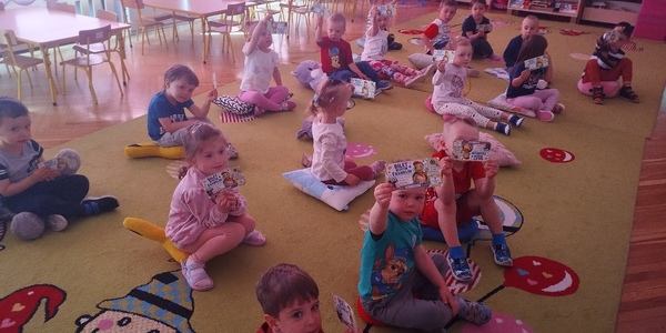 Dzieci z biletami do kina siedzą na poduszkach