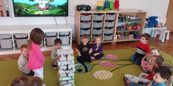 Dziewczynka układa wieżę z wytłaczanek po jajkach.