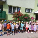 grupa dzieci na tle kwitnących róż.jpg