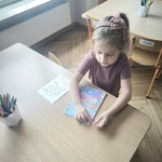 dziewczynka przystępuje do zadania w zeszycie.