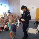 Antek i Gabrysia wręczają pani policjantce podziękowanie za spotkanie edukacyjne.