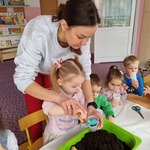 Dziewczynka i pani wsypują ziemię.jpg